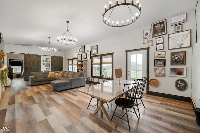 dining area with light hardwood / wood-style flooring and an inviting chandelier