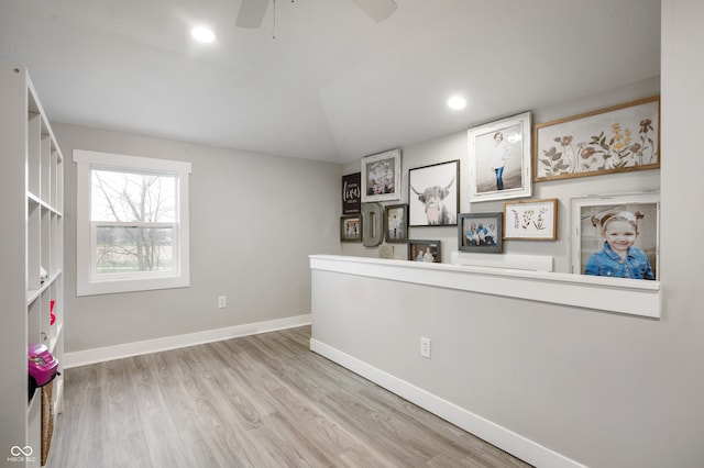 empty room featuring ceiling fan, lofted ceiling, and light hardwood / wood-style flooring