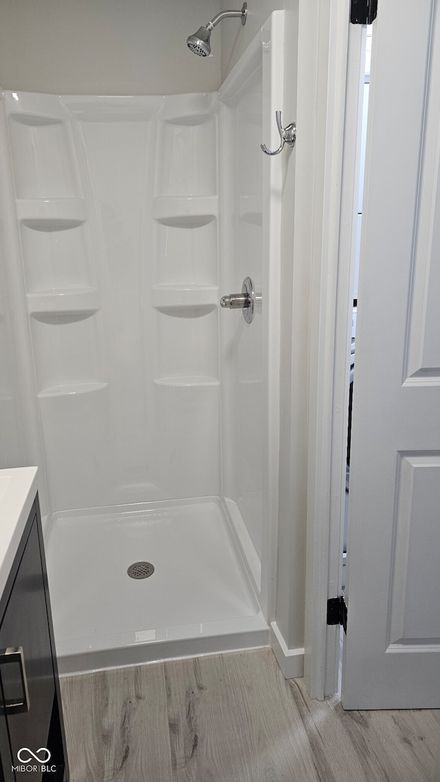 bathroom with vanity, hardwood / wood-style flooring, and walk in shower