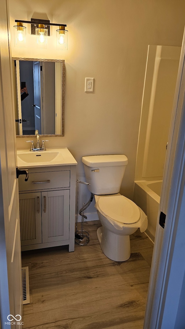 full bathroom with hardwood / wood-style floors, vanity, independent shower and bath, and toilet