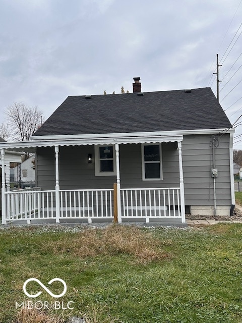 rear view of property with a porch and a yard