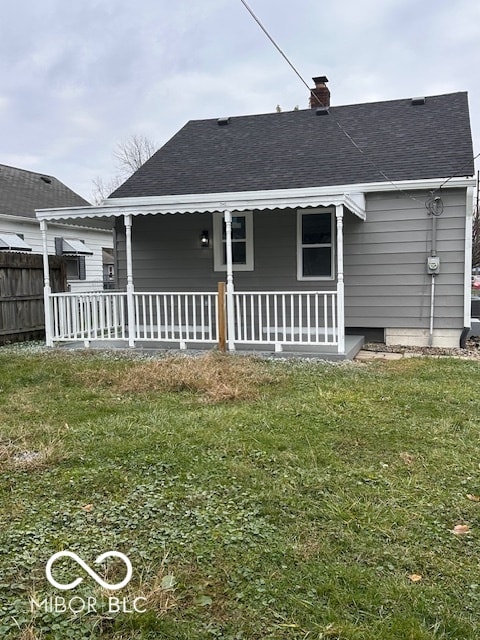 rear view of property with a porch and a yard