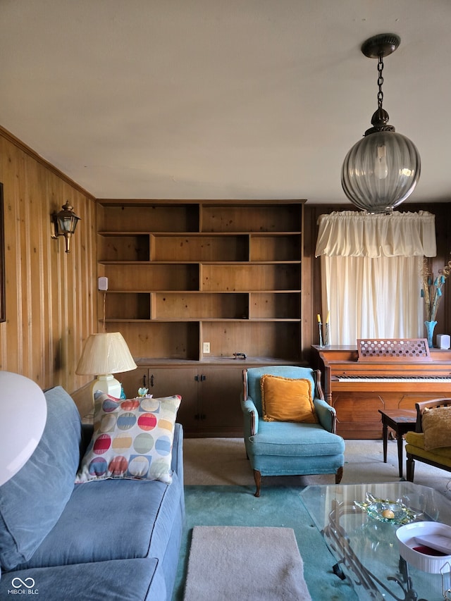 carpeted living room with wooden walls and ornamental molding