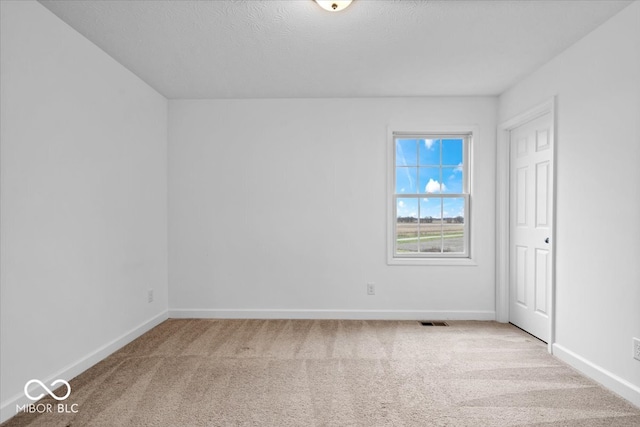 carpeted spare room featuring a textured ceiling