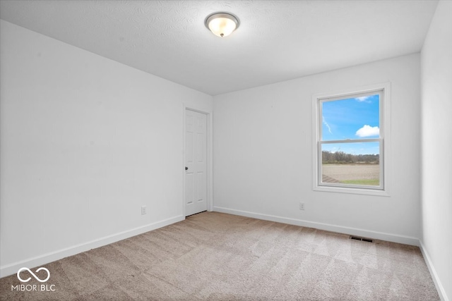 unfurnished room featuring carpet and a textured ceiling