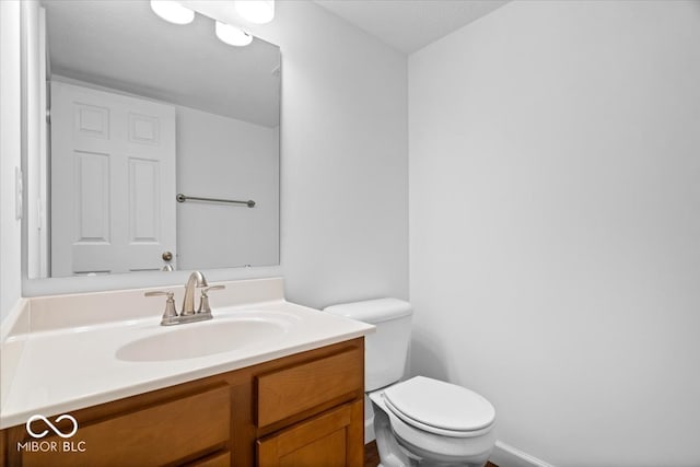 bathroom with vanity, toilet, and a textured ceiling