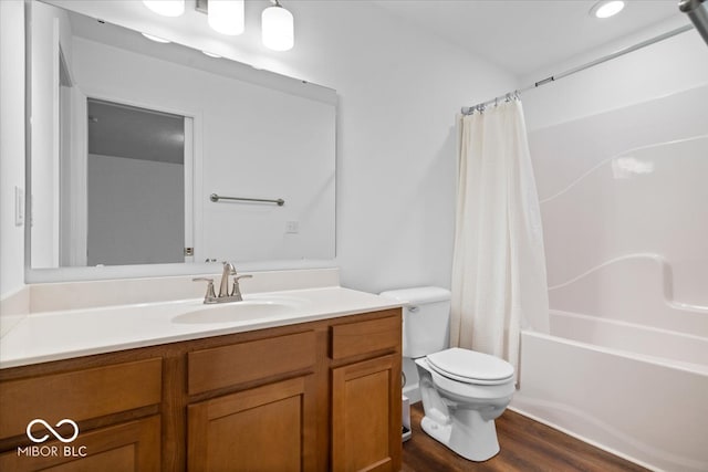 full bathroom with vanity, wood-type flooring, shower / tub combo, and toilet