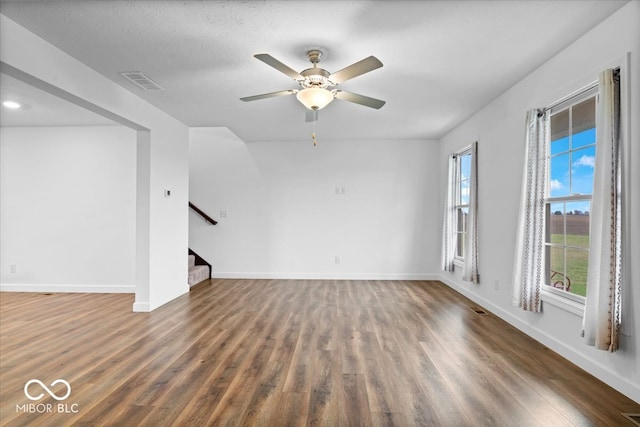 unfurnished living room featuring a textured ceiling, dark hardwood / wood-style floors, and ceiling fan