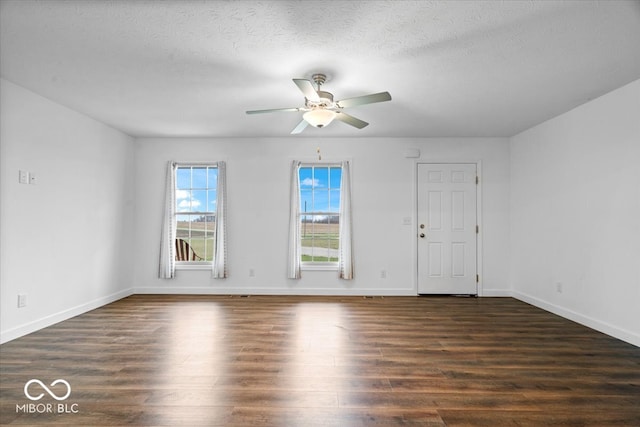 empty room with a textured ceiling, ceiling fan, and dark wood-type flooring