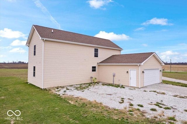 view of side of home with a garage and a lawn