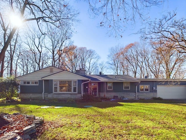 back of property with a yard and a garage