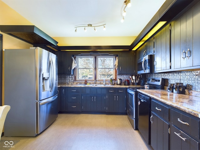 kitchen featuring sink, stainless steel appliances, tasteful backsplash, light stone counters, and light hardwood / wood-style flooring