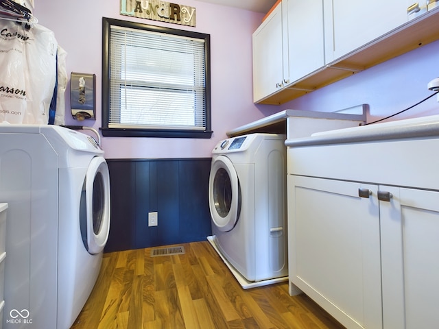 washroom with dark hardwood / wood-style floors, cabinets, and independent washer and dryer