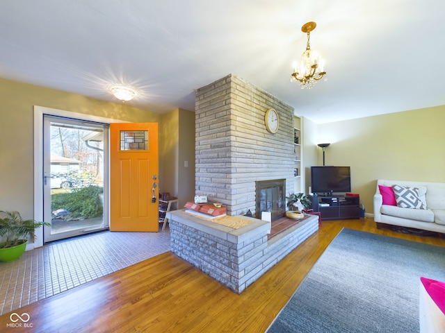 living room with a fireplace, wood-type flooring, and a chandelier