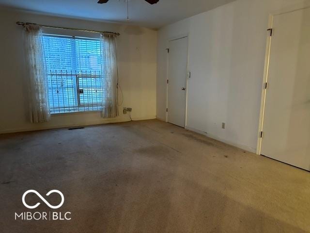 carpeted empty room featuring ceiling fan