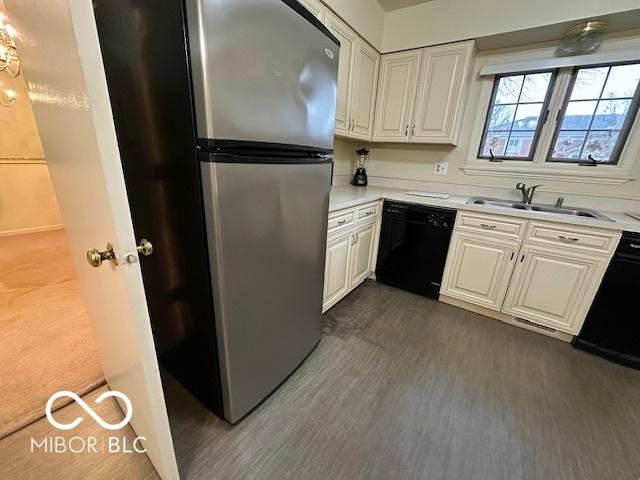 kitchen featuring sink, stainless steel fridge, dishwasher, white cabinetry, and dark hardwood / wood-style floors