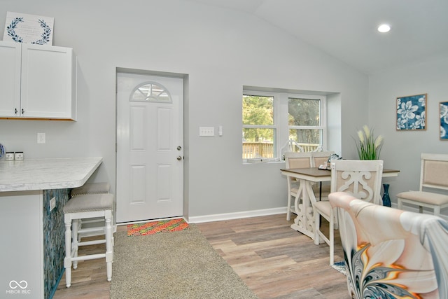 dining room featuring light hardwood / wood-style floors and vaulted ceiling