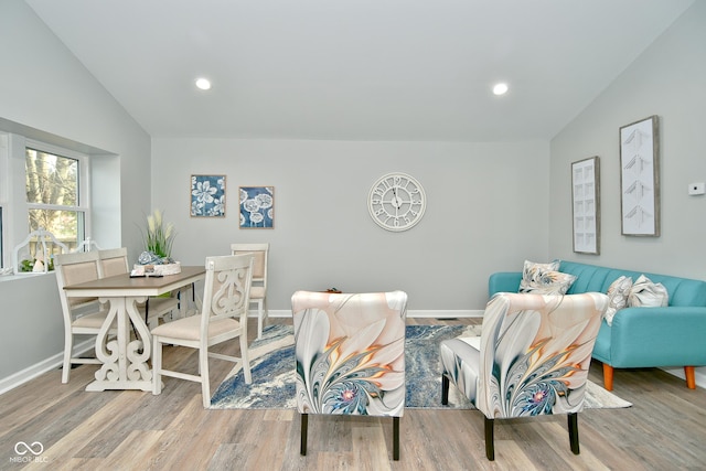 living room featuring lofted ceiling and light hardwood / wood-style flooring