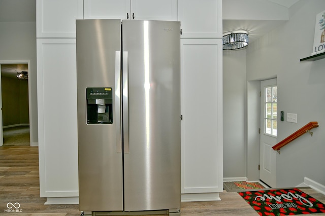 interior space featuring white cabinets, stainless steel fridge, and light hardwood / wood-style floors