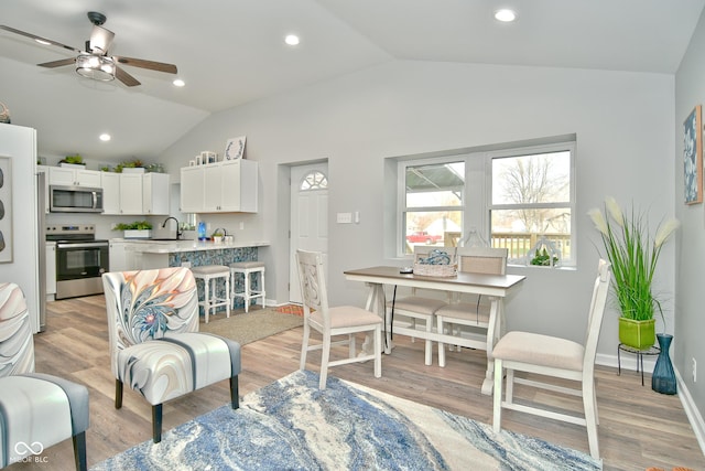 interior space with appliances with stainless steel finishes, light hardwood / wood-style floors, white cabinetry, and lofted ceiling