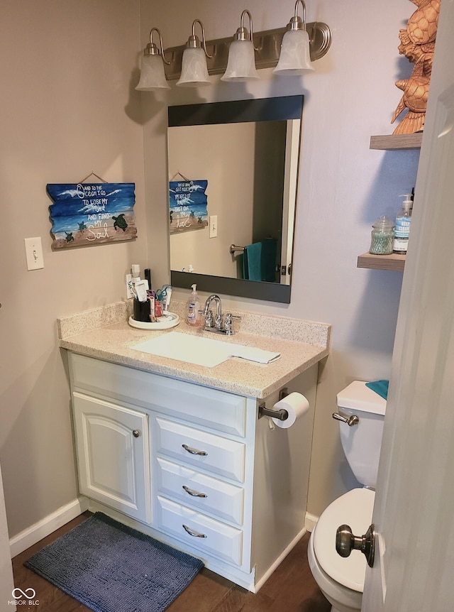 bathroom with hardwood / wood-style flooring, vanity, and toilet