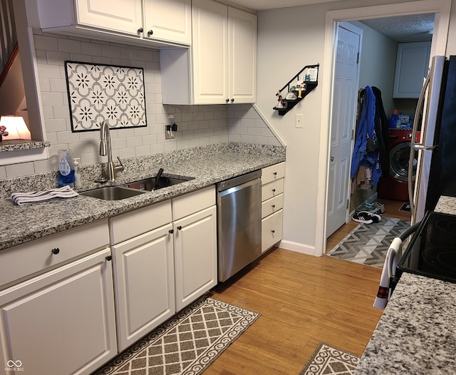 kitchen with light hardwood / wood-style floors, stainless steel dishwasher, white cabinetry, and sink