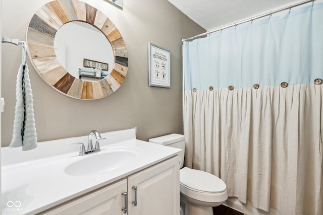 bathroom featuring vanity, walk in shower, and toilet