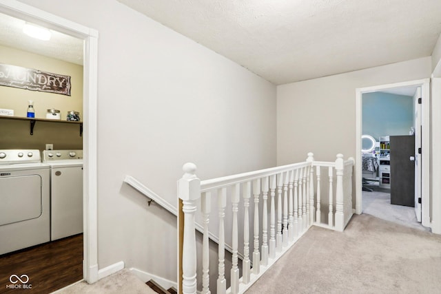 hall with carpet, washing machine and clothes dryer, and a textured ceiling