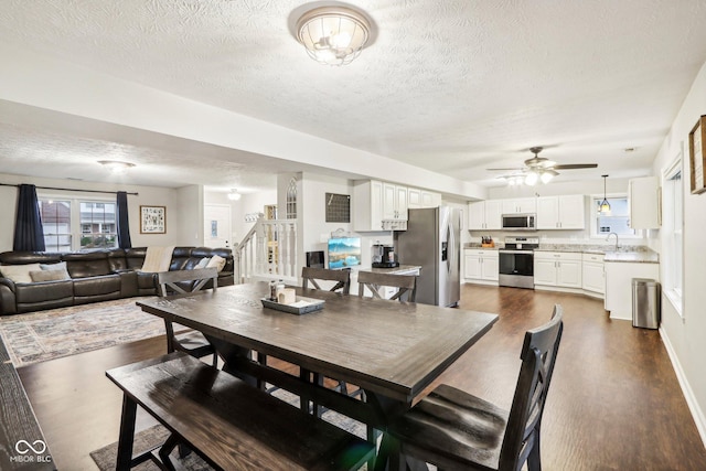 dining area with dark wood-type flooring, sink, and a textured ceiling