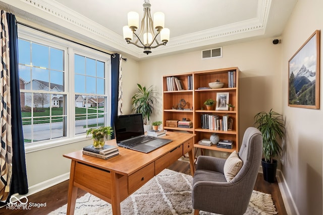 office with dark wood-type flooring, an inviting chandelier, and a tray ceiling