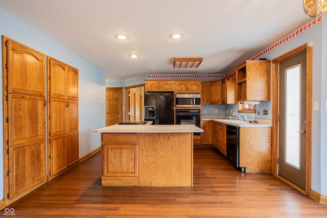 1510 S Greensboro Pike, New Castle, IN 47362 - kitchen featuring black appliances, a center island, sink, and hardwood / wood-style flooring