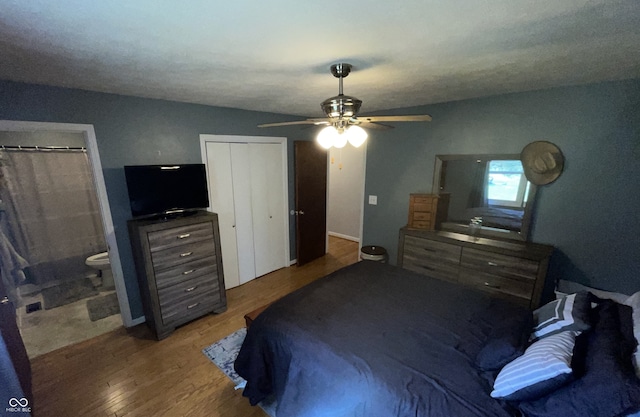 bedroom with ceiling fan, wood-type flooring, connected bathroom, and multiple closets