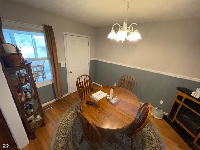 dining space with a notable chandelier and wood-type flooring