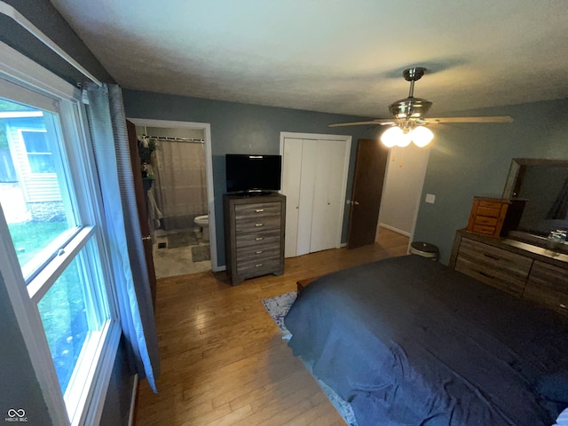 bedroom with wood-type flooring, ensuite bath, and ceiling fan