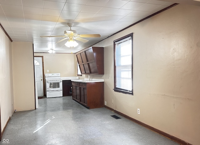 kitchen featuring ceiling fan, white range with electric cooktop, dark brown cabinets, and crown molding