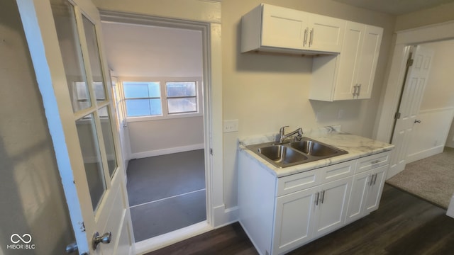 kitchen featuring dark hardwood / wood-style flooring, white cabinetry, and sink