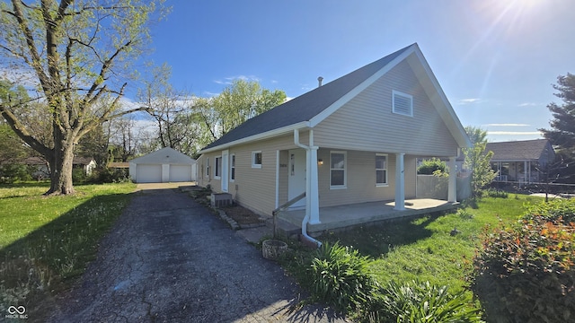 view of front of property with an outdoor structure, covered porch, and a detached garage