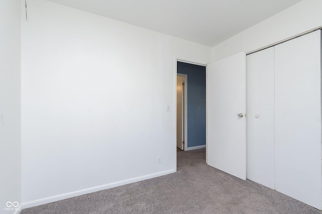 unfurnished bedroom featuring light colored carpet and a closet