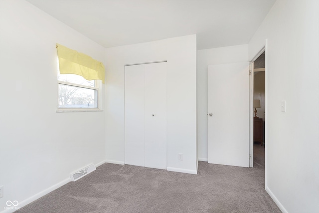 unfurnished bedroom with a closet and light carpet