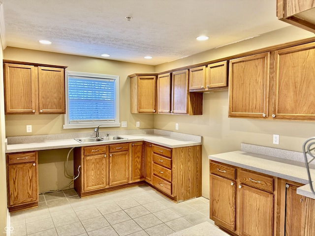 kitchen featuring a textured ceiling, light tile patterned flooring, and sink