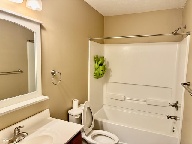 full bathroom featuring vanity, a textured ceiling,  shower combination, and toilet