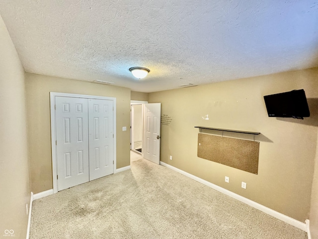 unfurnished bedroom with carpet, a textured ceiling, and a closet