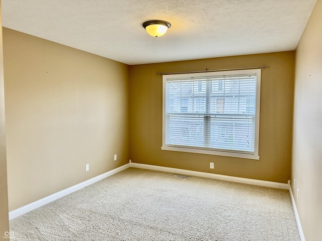 unfurnished room featuring carpet floors and a textured ceiling