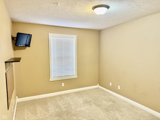 empty room featuring a textured ceiling and light carpet