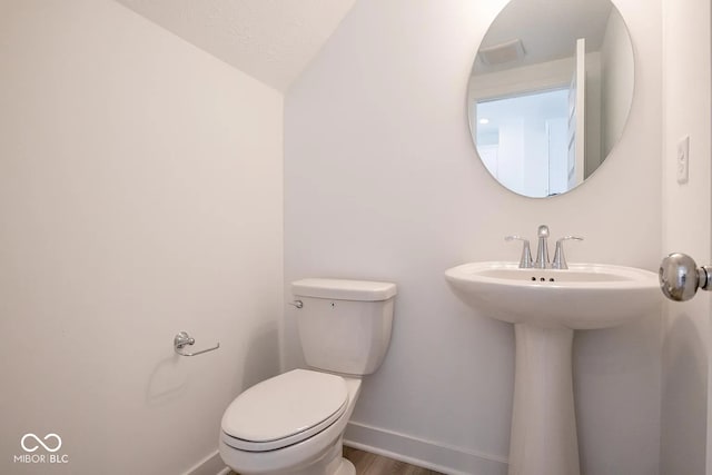 bathroom with hardwood / wood-style floors, toilet, and lofted ceiling