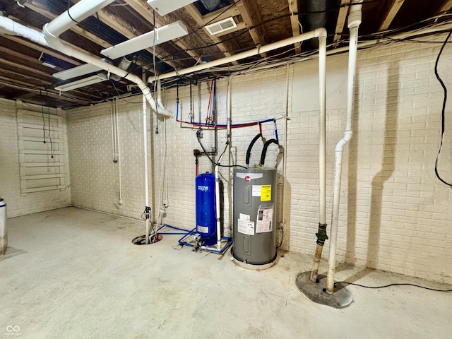 basement featuring brick wall and water heater