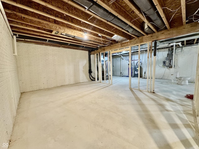 basement featuring electric panel and brick wall