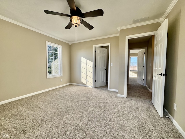 unfurnished bedroom with multiple windows, carpet floors, ceiling fan, and ornamental molding