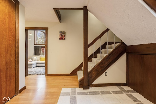 stairway featuring a textured ceiling and hardwood / wood-style flooring