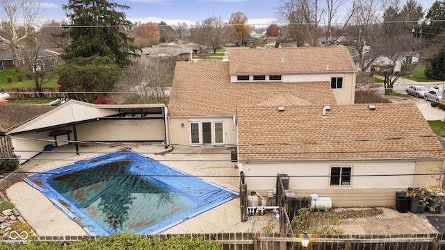 rear view of property with a covered pool and a patio area